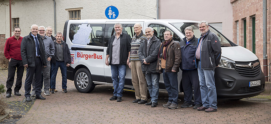 Bürgermeister Albert Ungermann und die ehrenamtlichen Fahrer des Bürgerbusses nehmen das neue Fahrzeug in Augenschein.